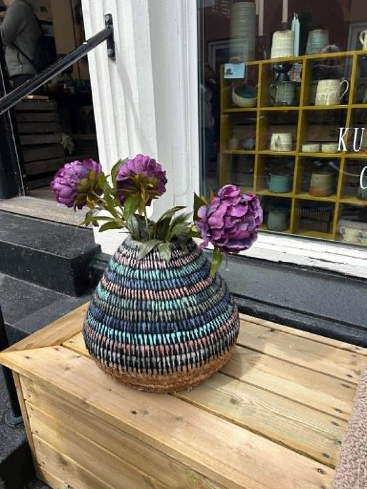 Farverig keramikvase med tæt løbbinding og lilla blomster